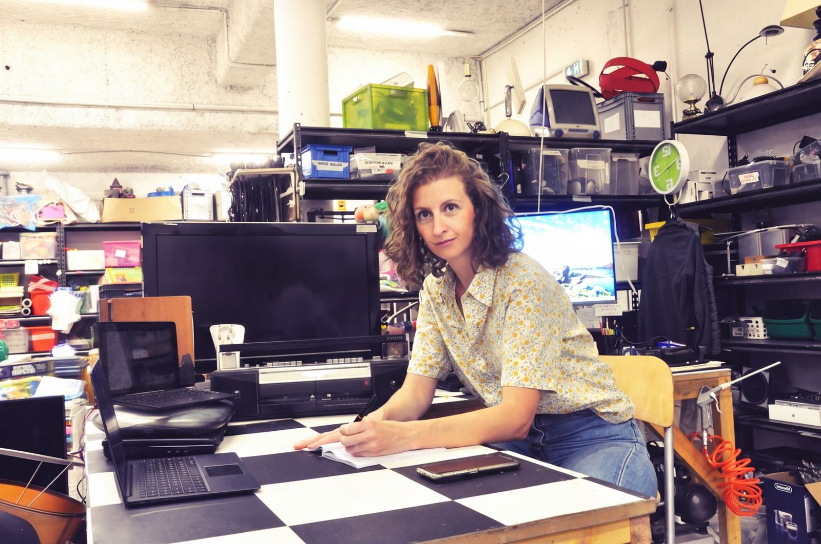 Caroline Grosjean assise à un bureau dans une ressourcerie, un stylo à la main
